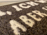 Detail schwarzeFußmatte mit weißem Text