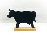 Schwarze Kuh mit Ständer aus Holz