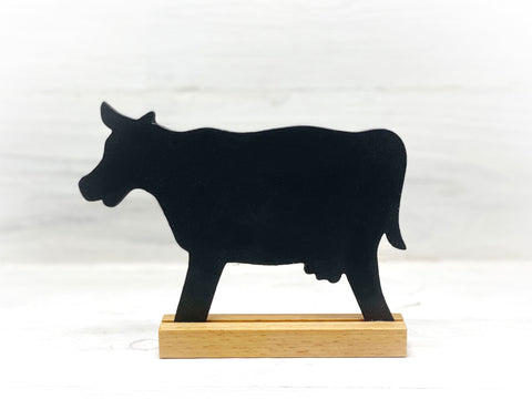 Schwarze Kuh mit Ständer aus Holz